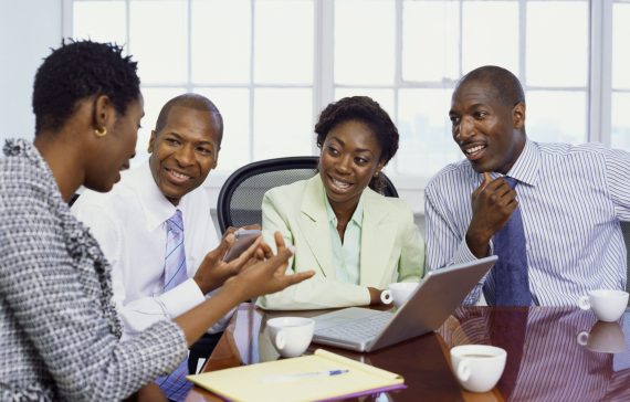two businessmen and two businesswomen discussing in an office